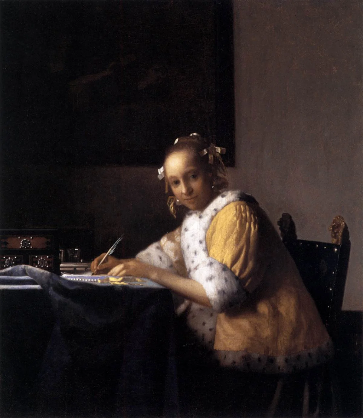 A Lady Writing by Johannes Vermeer, c. 1665 &mdash; a young woman at her writing desk looking up mid-letter